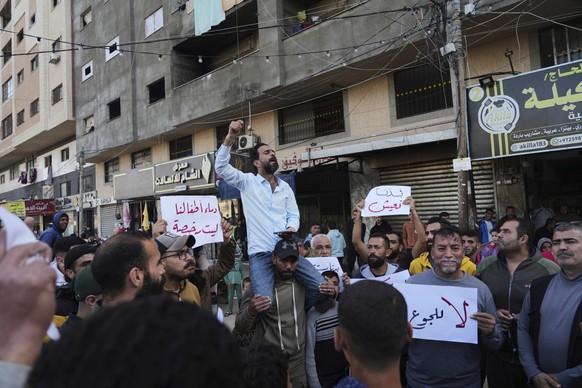 Palestinians hold signs and chant slogans against Hamas during anti-war protests in a rare show of public anger against the militant group that rules the territory, in Deir al-Balah Gaza Strip, Wednes ...