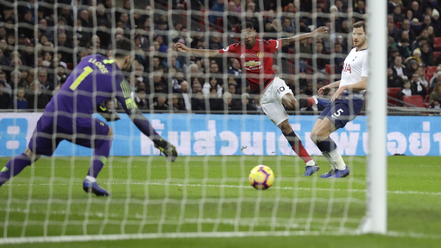 Manchester United&#039;s Marcus Rashford, center, scores his side&#039;s first goal passing Tottenham goalkeeper Hugo Lloris, left, and Tottenham&#039;s Jan Vertonghen, right, during the English Premi ...