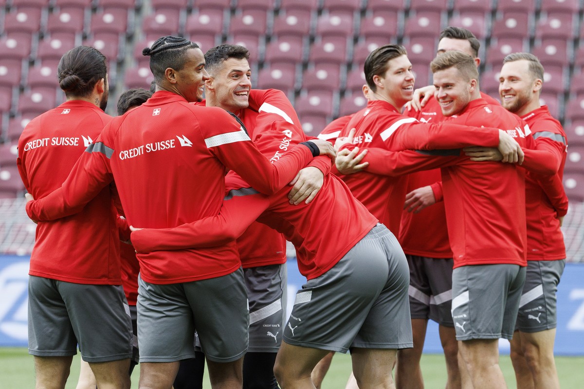 epa10545636 Switzerland's defender Manuel Akanji (2-L) and Switzerland's midfielder Granit Xhaka (3-L) smile with their teammates during a training session in Geneva, Switzerland, 27 March 2 ...