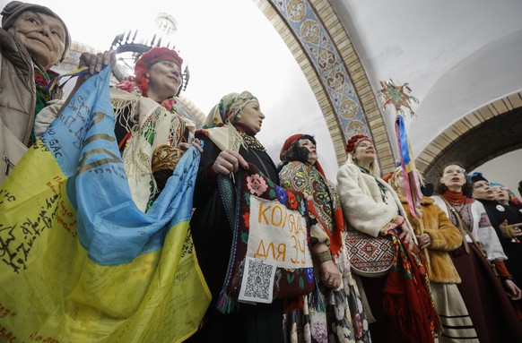 epa11800207 Ukrainians sing Christmas carols to collect donations for the Ukrainian army at an underground metro station as part of the New Year celebrations in downtown Kyiv, Ukraine, 31 December 202 ...