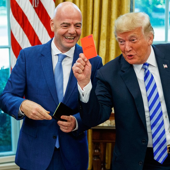 FILE - President Donald Trump holds up a red card during a meeting with FIFA president Gianni Infantino, center, and United States Soccer Federation president Carlos Cordeiro, left, in the Oval Office ...