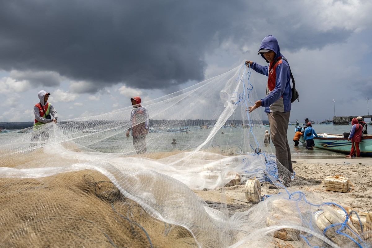 epa11709293 A fisherman sorts his fishing net at Kedonganan beach in Bali, Indonesia, 08 November 2024. Indonesian President Prabowo Subianto on 05 November 2024 has issued a policy that will grant de ...
