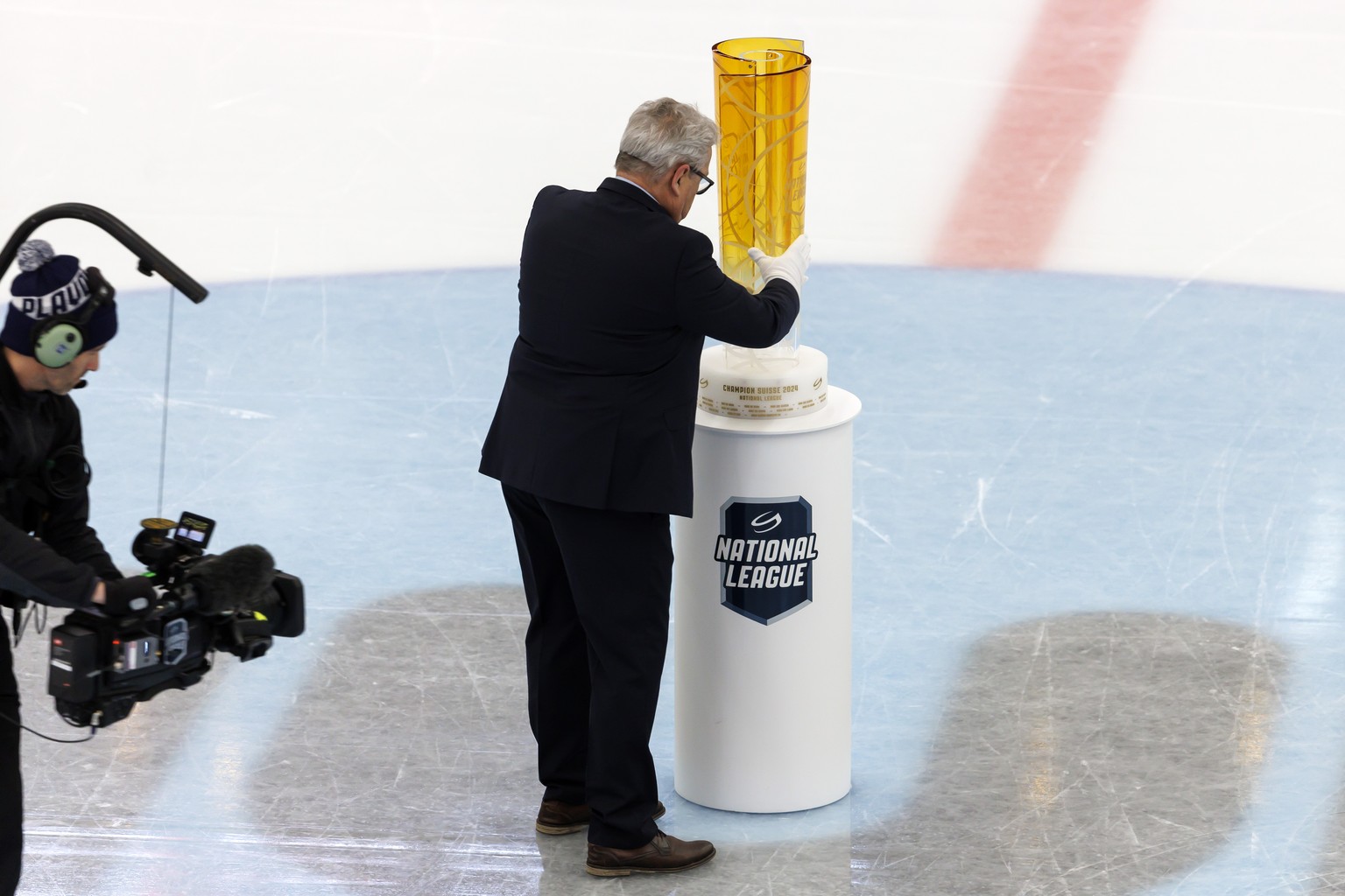 Willi Voegtlin, responsable des calendriers de la Na?ional League, depose le trophee de Na?ional League, lors du 2eme match de la finale de play-off du championnat suisse de hockey sur glace de Nation ...