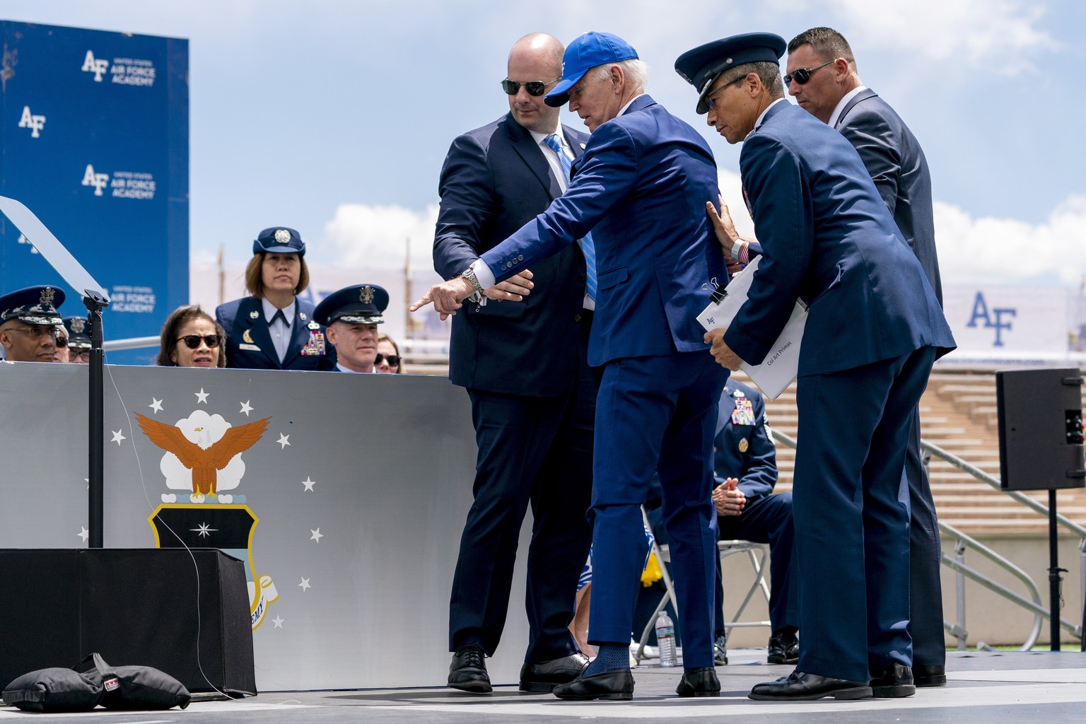 President Joe Biden points to sandbags after falling on stage during the 2023 United States Air Force Academy Graduation Ceremony at Falcon Stadium, Thursday, June 1, 2023, at the United States Air Fo ...
