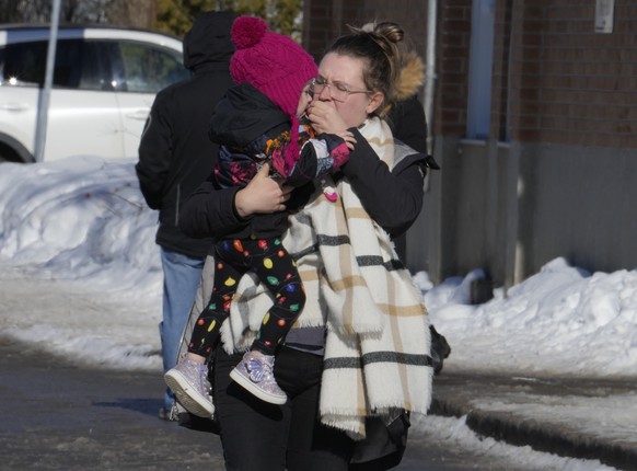 A woman carries a child from a daycare centre after a city bus crashed into the facility in Laval, Quebec, Wednesday, Feb.8, 2023. At least eight people including several children have been sent urgen ...