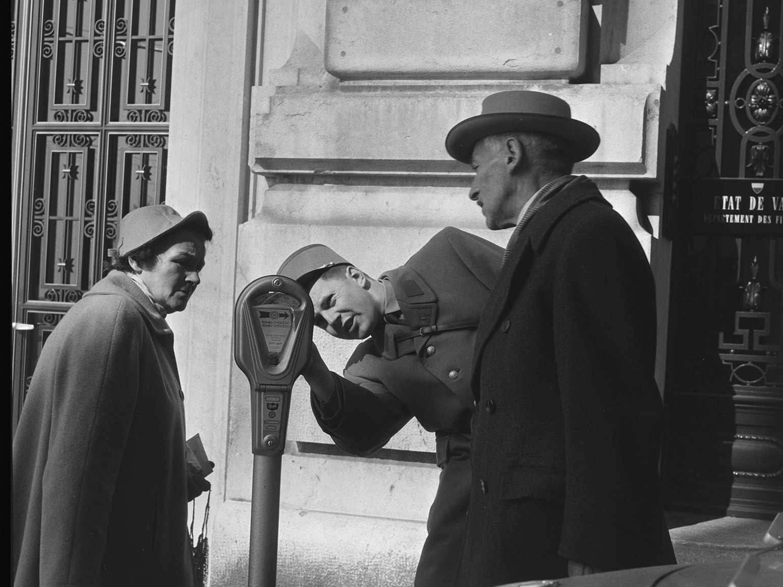 Ein Verkehrspolizist erklärt einer Passantin und einem Passanten eine Parkuhr, Lausanne, 1959
https://permalink.nationalmuseum.ch/100639352