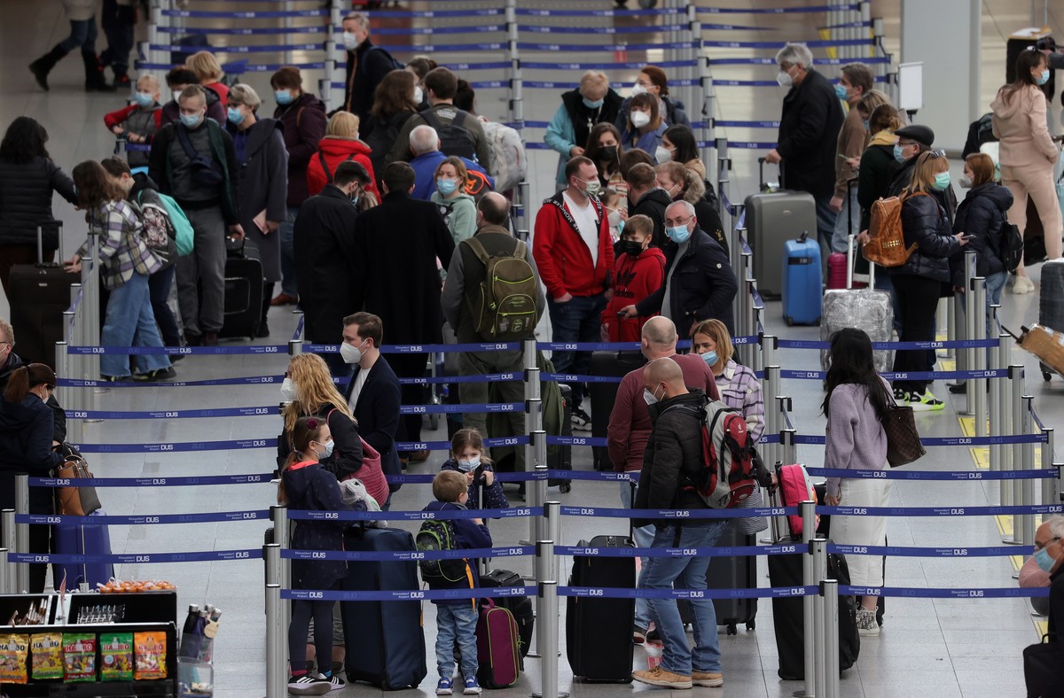 epa09099157 Passengers wait in the check-in line at the Dusseldorf International Airport in Dusseldorf, Germany, 26 March 2021. German tourist are set to travel to the Spanish island of Mallorca over  ...