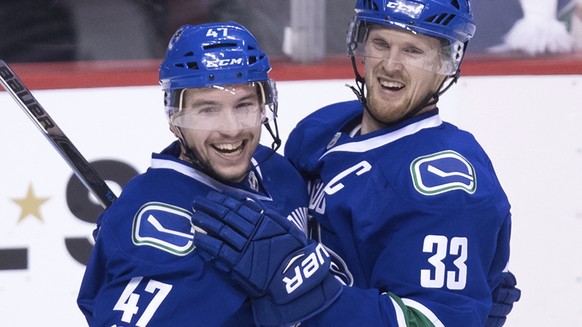 Vancouver Canucks' Sven Baertschi, left, and Henrik Sedin, of Sweden, celebrate Baertschi's second goal against the Colorado Avalanche during the third period of an NHL hockey game in Vancou ...