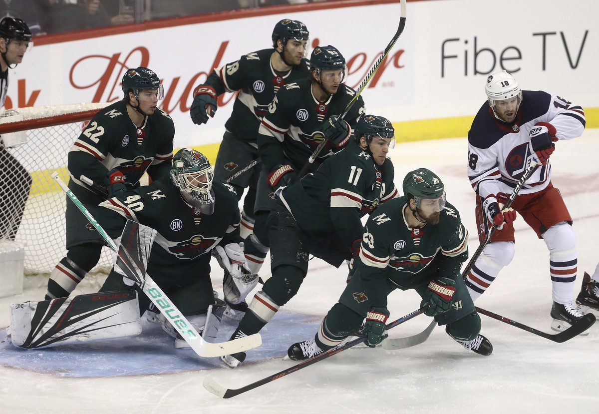 Minnesota Wild's Kevin Fiala (22), goaltender Devan Dubnyk (40), Luke Kunin (19), Jonas Brodin (25), Zach Parise (11) and Greg Pateryn (29) gather in front of the net as Winnipeg Jets' Bryan ...
