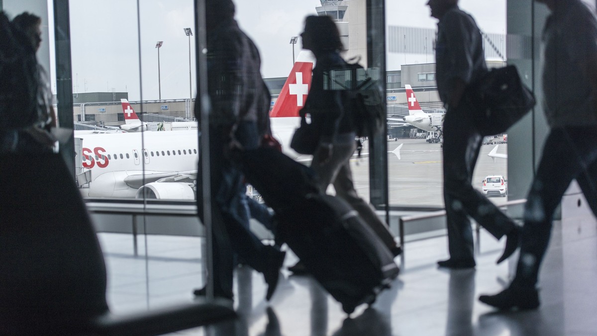 Passengers are on the way to and from the aeroplanes at Zurich Airport, pictured in Kloten, Switzerland, on July 31, 2014. (KEYSTONE/Christian Beutler)
