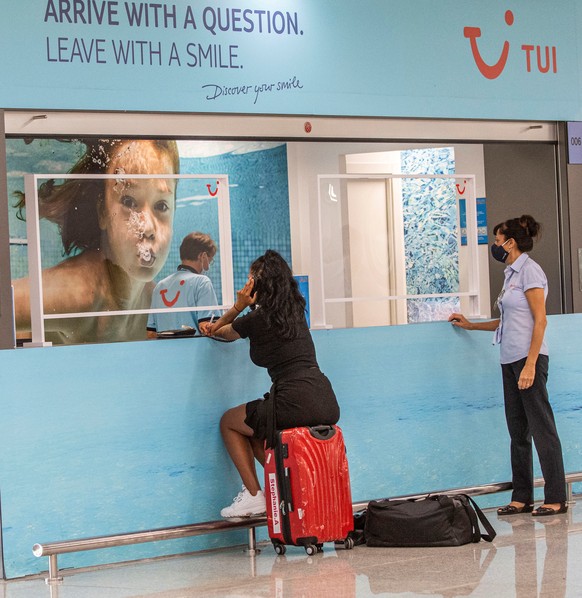 epa08605626 A traveler with her baggage waits next to a stand of TUI travel company at Palma de Mallorca&#039;s Airport in Palma, Balearic Islands, Spain, 15 August 2020. German traveler company TUI o ...