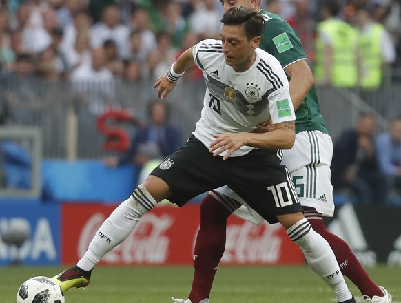 epa06816360 Mesut Oezil (front) of Germany and Hector Herrera of Mexico in action during the FIFA World Cup 2018 group F preliminary round soccer match between Germany and Mexico in Moscow, Russia, 17 ...