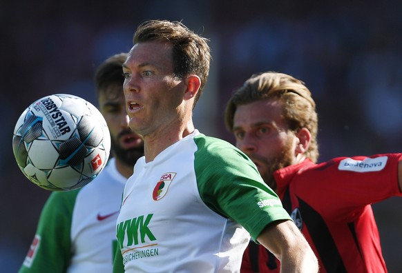 21.09.2019, Baden-Wuerttemberg, Freiburg: FuÃball: Bundesliga, SC Freiburg - FC Augsburg, 5. Spieltag im Schwarzwaldstadion. Stephan Lichtsteiner (l) von Augsburg schaut auf den Ball, Lucas Hoeler (r ...