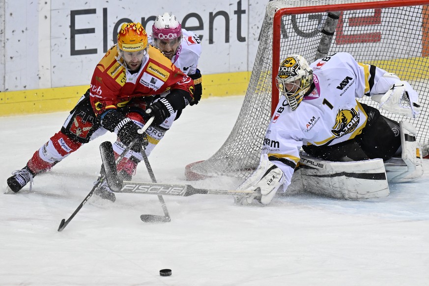 Berns PostFinance Top Scorer Christopher DiDomenico, links, im Duell mit Ajoies Matteo Romanenghi, Mitte, und Ajoies Torhueter Tim Wolf im Eishockey Qualifikationsspiel der National League zwischen de ...