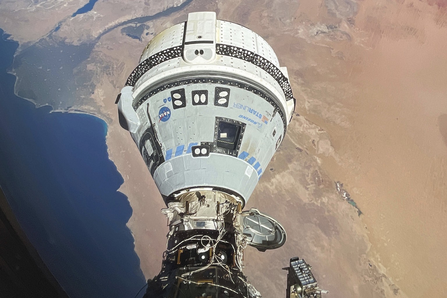 FILE - This photo provided by NASA shows the Starliner spacecraft docked to the Harmony module of the International Space Station, orbiting 262 miles above Egypt&#039;s Mediterranean coast, on June 13 ...
