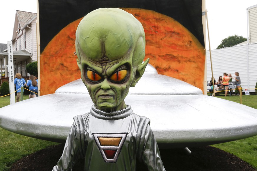 A figure representing a green alien is positioned in front of the permanent flying saucer replica in Mars, Pa. on Friday, June 19, 2015. The small western Pennsylvania town has NASA joining in with a  ...