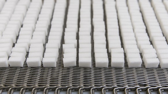Sugar cubes lie on a conveyor belt, pictured on November 22, 2013, in the sugar factory in Aarberg, canton of Bern, Switzerland. The Zuckerfabriken Aarberg und Frauenfeld (ZAF, sugar factories in Aarb ...
