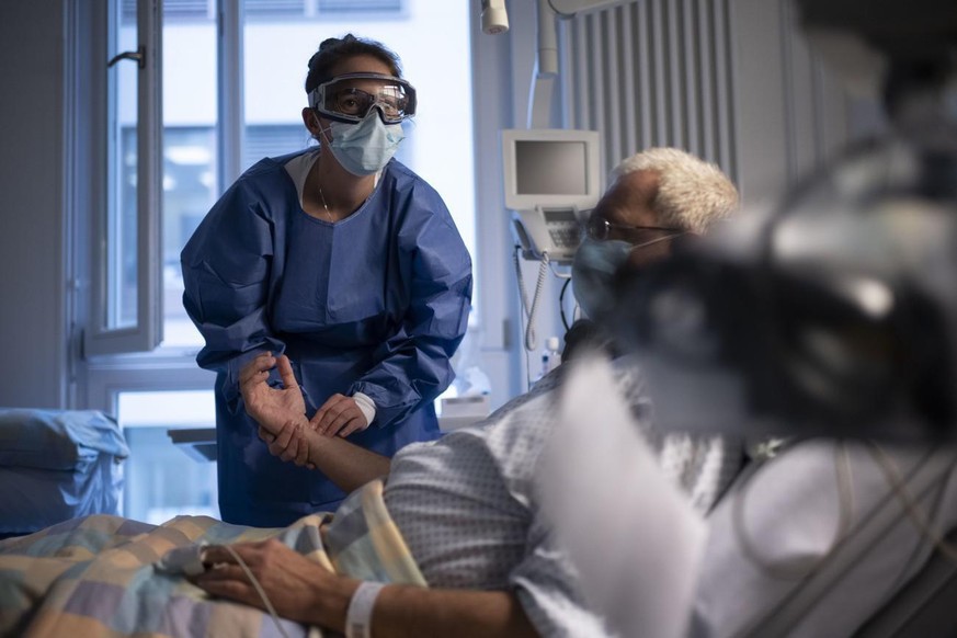Nora Tschanz, Gruppenleiterin Pflege, misst den Puls eines Covid Patienten in der Isolationsstation des Universitätsspital Zürich.