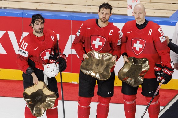 Switzerland&#039;s forward Andres Ambuehl, left, Switzerland&#039;s forward Nino Niederreiter, centre, and Switzerland&#039;s defender Christian Marti, pose with their trophy of Swiss best players of  ...