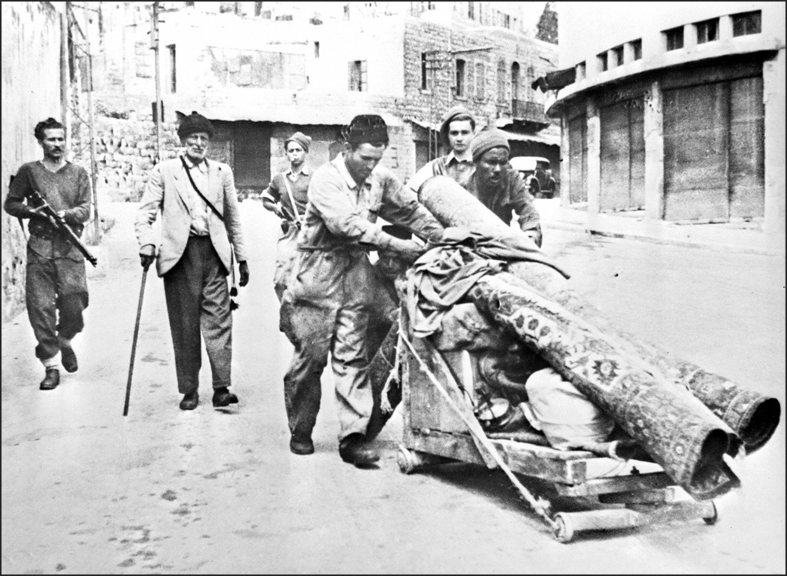 Three members of Haganah, the Jewish Agency self-defence force, escort May 12, 1948 in Haifa three Palestinian Arabs expelled from the city after the Jewish forces took over the harbor April 22, 1948. ...
