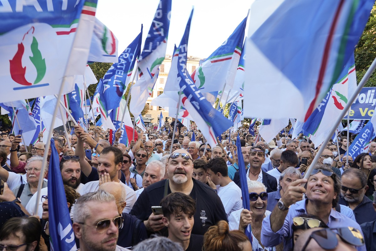 People wave flags as Right-wing party Brothers of Italy's leader Giorgia Meloni addresses a rally to starts her political campaign ahead of Sept. 25 general elections, in Ancona, Italy, Tuesday,  ...