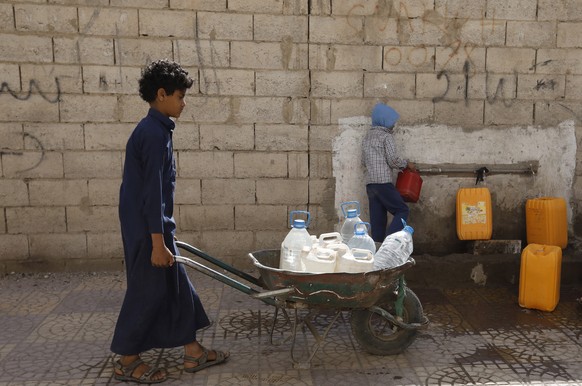 epa09863814 Yemenis collect drinking water from a donated water pipe on the roadside in Sana&#039;a, Yemen, 31 March 2022 (issued 01 April 2022). The World Bank has approved an additional 300 million  ...