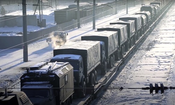 In this photo taken from video provided by the Russian Defense Ministry Press Service, Russian military vehicles on a railway platform on their way to attend a joint military drills in Belarus, in Rus ...