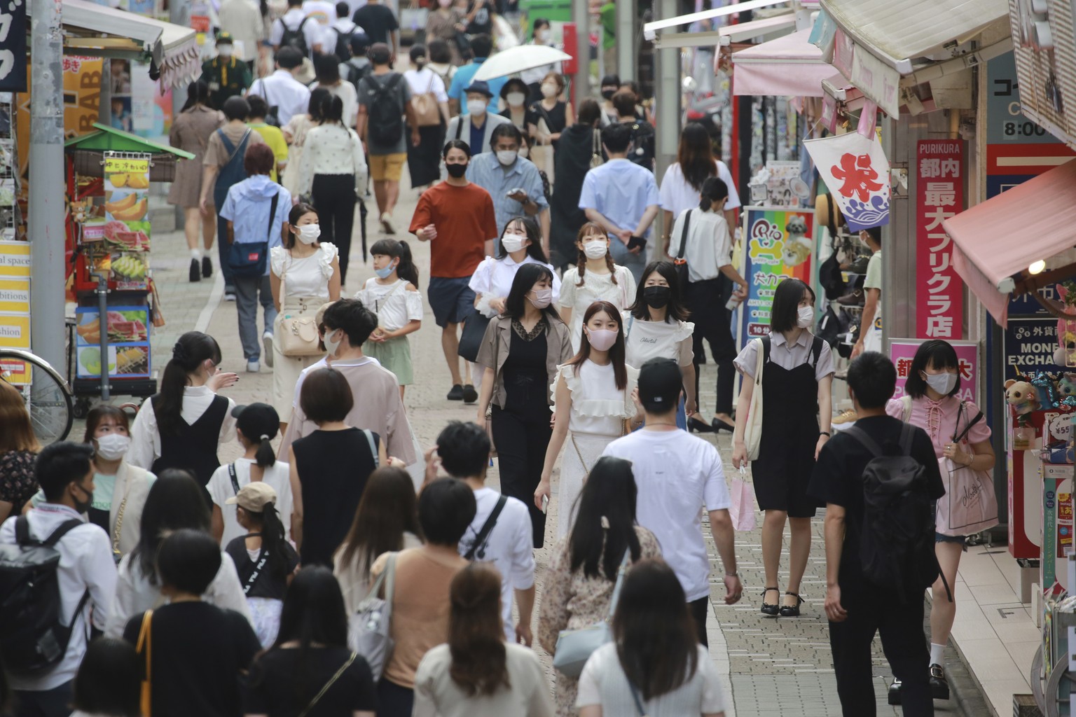 People wearing face masks to protect against the spread of the coronavirus walk through Takeshita street in Tokyo, Wednesday, July 28, 2021. Tokyo Gov. Yuriko Koike on Wednesday urged younger people t ...