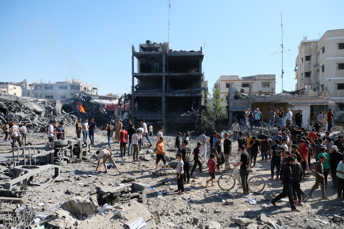 Palestinians gather around the site of an Israeli military drone strike on a blacksmith shop in Gaza City's Sabra neighborhood killing at least four Palestinians and wounded another, according to ...