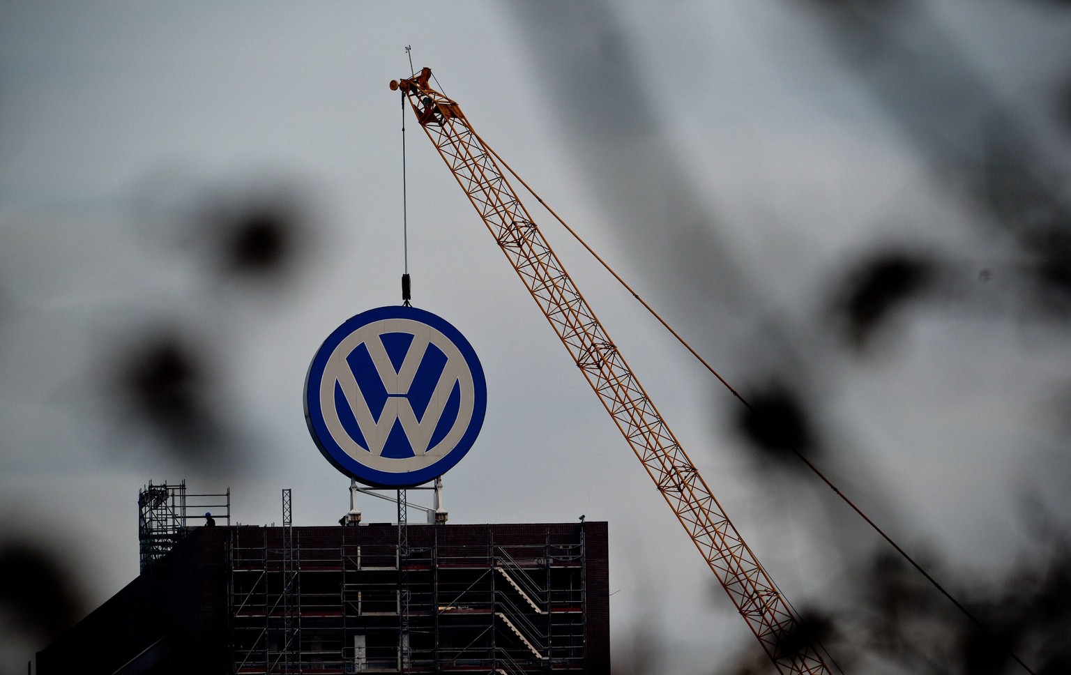 ARCHIV - ZUM ANGEKUENDIGTEN WELTWEITEN STELLENABBAU VON 30&#039;000 JOBS BEI VW STELLEN WIR IHNEN DIESES ARCHIVBILD ZUR VERFUEGUNG - Construction work and a crane can be seen over the VW logo on the a ...