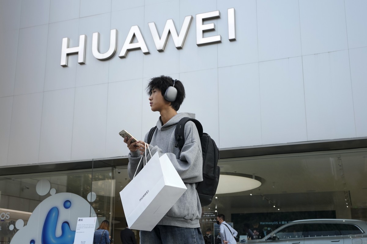 FILE - A customer carries his purchased Huawei product outside a Huawei store after he attended the Huawei new product launch conference in Beijing, on Sept. 25, 2023. (AP Photo/Andy Wong, File)
China ...