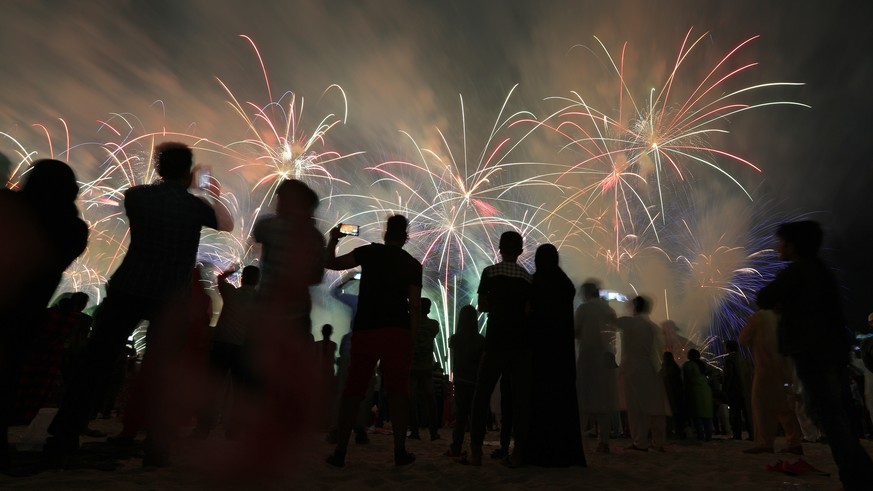 epa07204517 People watch fireworks illuminate the sky over the Corniche of Abu Dhabi as a performance to celebrate the UAE&#039;s 47th National Day and the Year of Zayed in Abu Dhabi, United Arab Emir ...