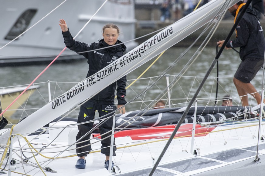 epa07800292 16-year-old climate change activist Greta Thunberg waves from aboard the Malizia II boat as it arrives in New York, USA 28 August 2019. Thunberg, who has inspired student protests around t ...