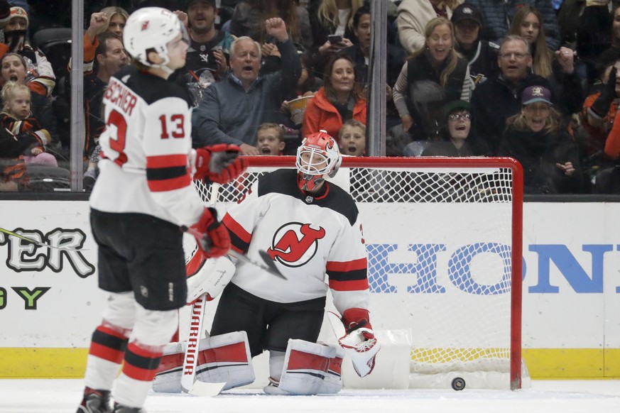 New Jersey Devils goaltender Cory Schneider and Nico Hischier react after a goal by Anaheim Ducks right wing Jakob Silfverberg during the first period of an NHL hockey game in Anaheim, Calif., Sunday, ...