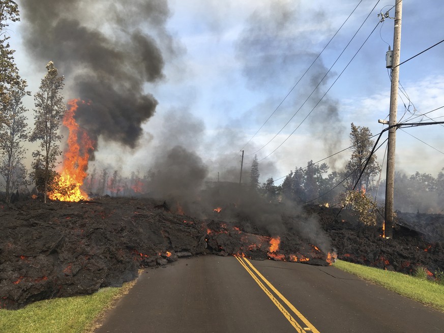 In this Saturday, May 5, 2018, photo provided by the U.S. Geological Survey, lava from Fissure 7 slowly advances to the northeast on Hookapu Street in the Leilani Estates subdivision in Pahoa, Hawaii. ...