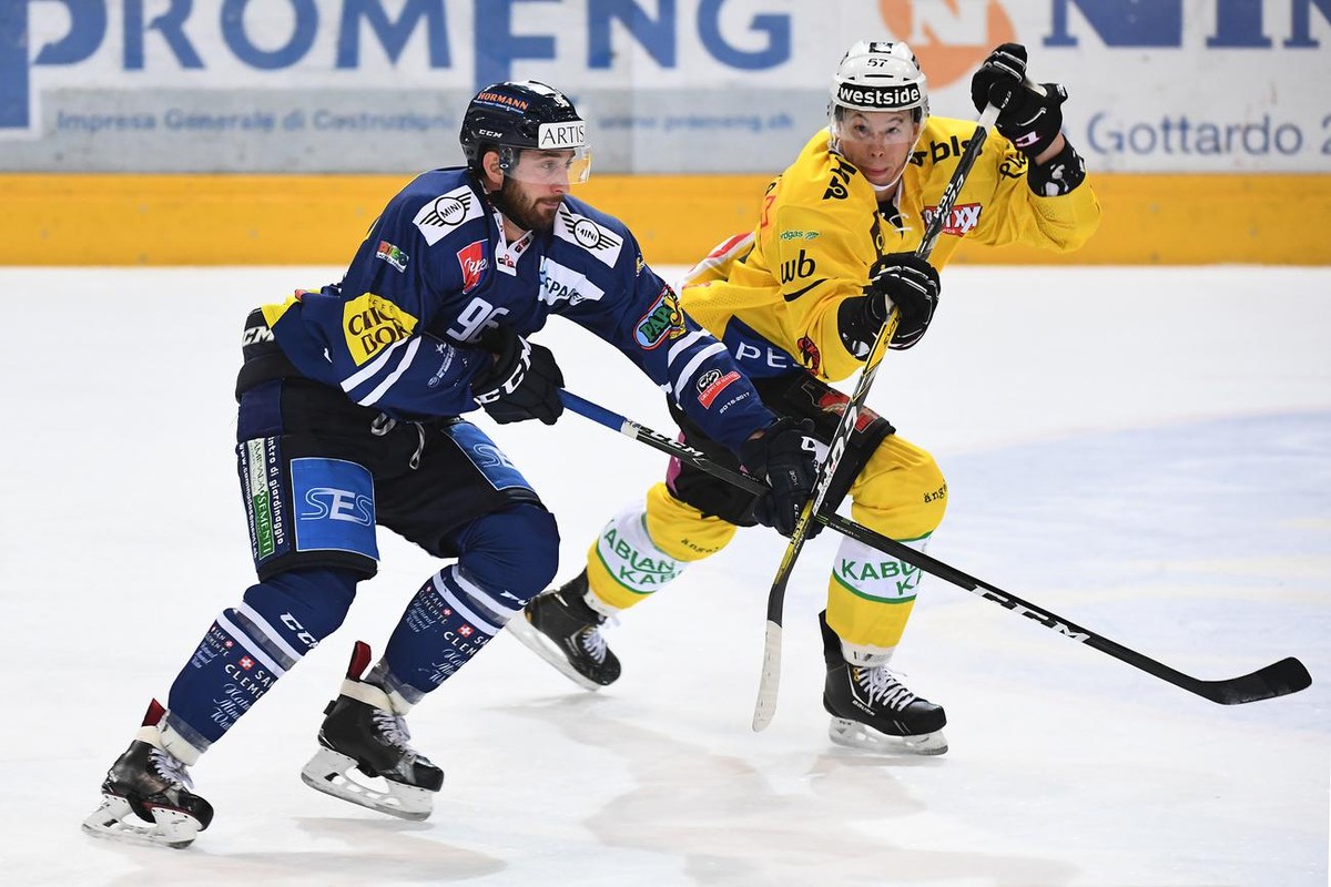 Ambri's Adrien Lauper, left, fights for the puck with Bern's player Jeremie Kamerzin, right, during the preliminary round game of National League A (NLA) Swiss Championship 2016/17 between H ...