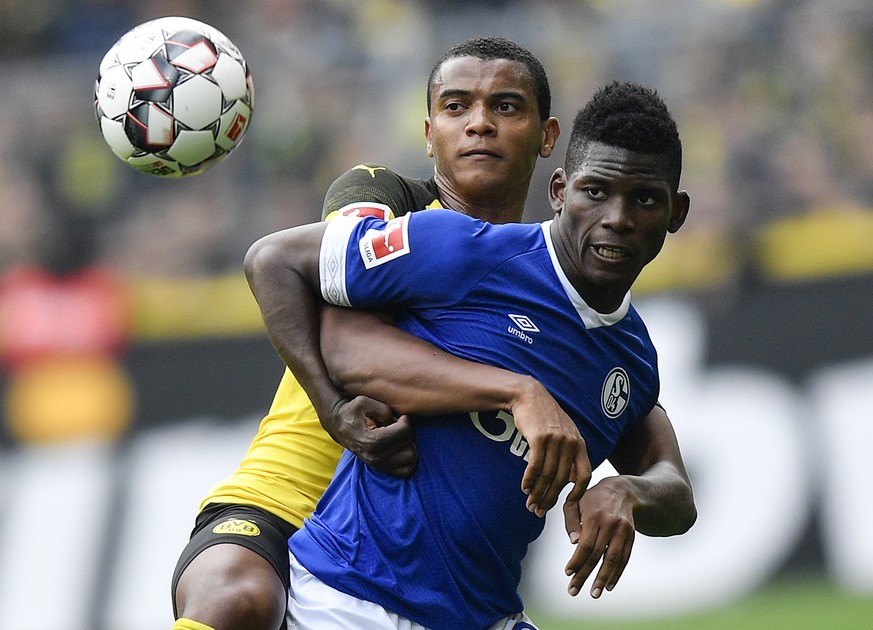 Schalke&#039;s Breel Embolo, right, and Dortmund&#039;s Manuel Akanji challenge for the ball during the German Bundesliga soccer match between Borussia Dortmund and FC Schalke 04 in Dortmund, Germany, ...