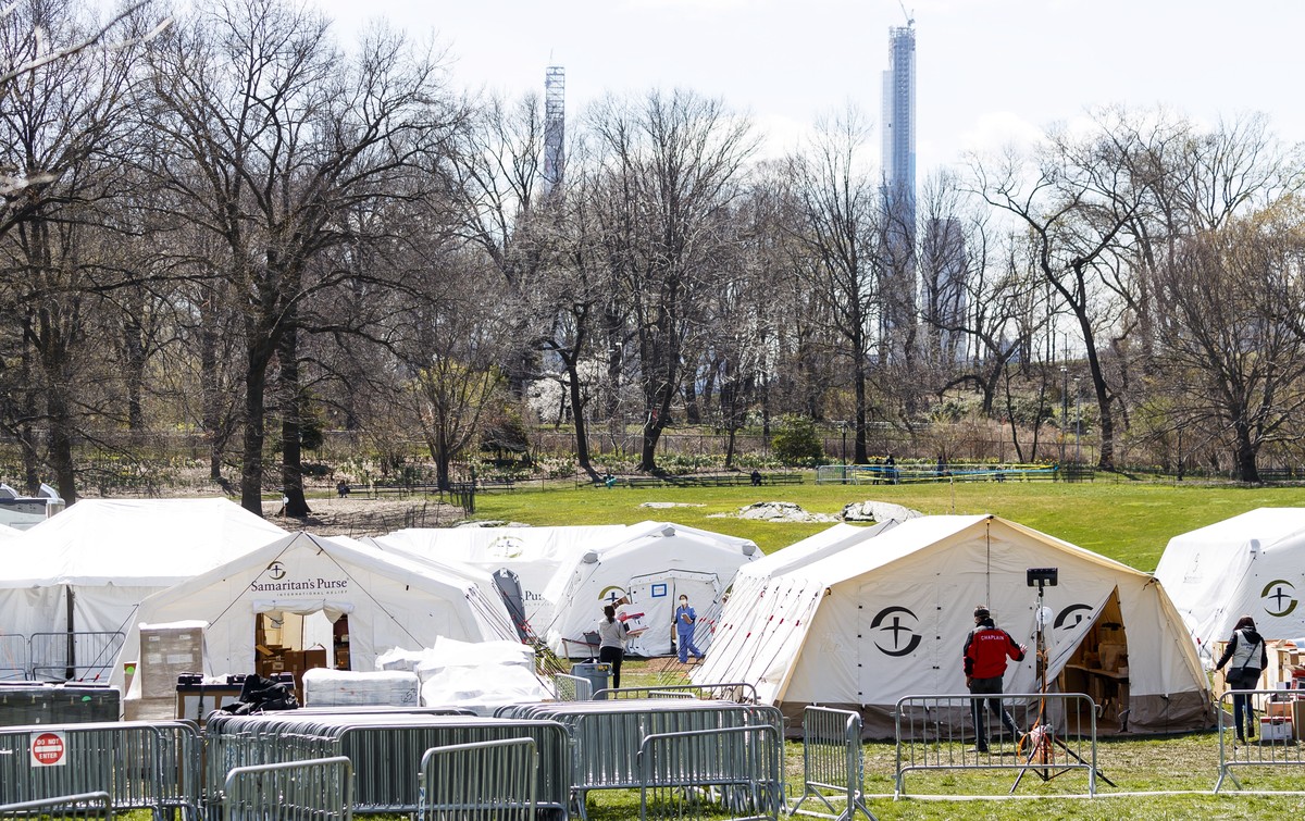 epa08337715 Healthcare workers walk through tents at the Samaritan's Purse field hospital which has been set up in Central Park across the street from the Mount Sinai Hospital in New York, New Yo ...