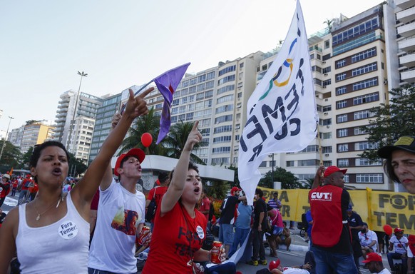 epa05456823 Protestors from the union CUT (Unified Workers&#039; Central) and PSTU (Unified Socialist Workers&#039; Party) during a protest along Copacabana beach prior to the opening ceremony of the  ...