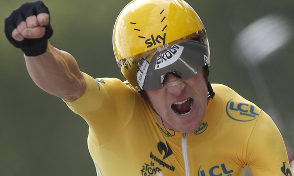 FILE - In this July 21, 2012 file photo, Bradley Wiggins of Britain, wearing the overall leader&#039;s yellow jersey, celebrates as he crosses the finish line of the 19th stage of the the Tour de Fran ...