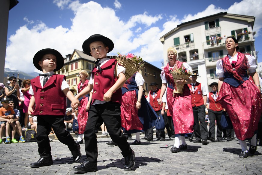 Des jodleuses en costume traditionel defilent en chantant avec des enfants lors du cortege de la 30eme edition de la Fete federal de jodler (Eidgenoessisches Jodlerfest) ce dimanche 25 juin 2017 a Bri ...