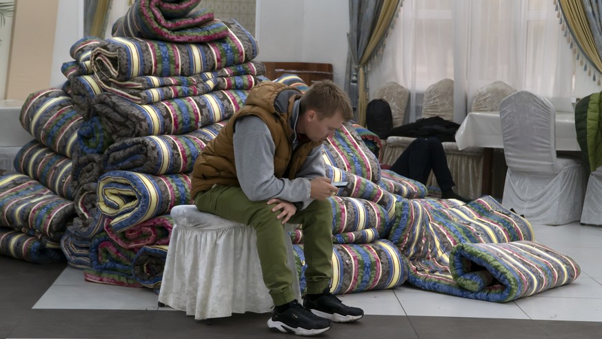 A Russian man rests in at temporary accommodation facility after crossing the border into Kazakhstan from the Mariinsky border crossing, about 400 km (250 miles) south of Chelyabinsk, in Russia, to Ka ...