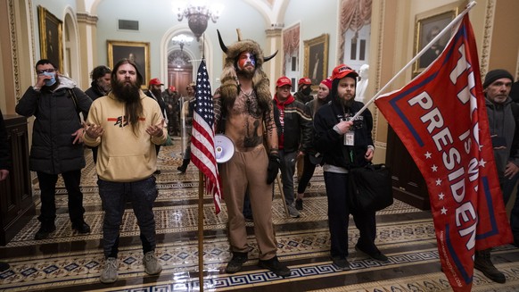 epa08976298 (FILE) - Supporters of US President Donald J. Trump, including &#039;QAnon Shaman&#039; Jacob Anthony Angeli Chansley (C), stand by the door to the Senate chambers after they breached the ...