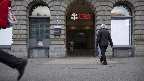 epa11830358 A person passes the logo of the Swiss bank UBS on the former main building of Credit Suisse on Paradeplatz in Zurich, Switzerland, 17 January 2025. The headquarters of Credit Suisse was lo ...