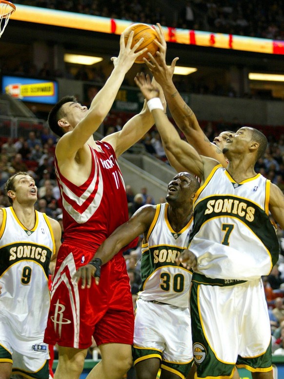 Seattle Supersonics&#039; Vitaly Potapenko (L) looks on as Yao Ming (C) of the Houston Rockets towers over Sonics&#039; Reggie Evans (30) and Rashard Lewis (R) during their NBA basketball match at Key ...