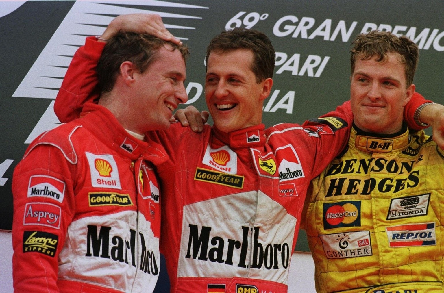 ICN03-19980913-MONZA, ITALY: German Michael Schumacher (C) of the team Ferrari celebrates with team-mate Eddie Irvine (L) of Ireland and brother Ralph (R) of the team Jordan on the winners&#039; podiu ...