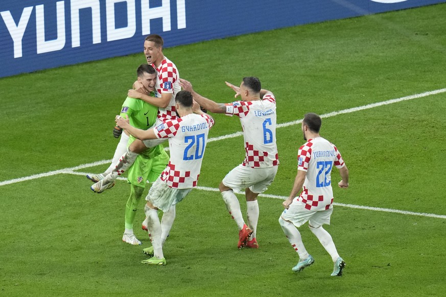 Croatia&#039;s goalkeeper Dominik Livakovic celebrates with his teammates at the end of the World Cup round of 16 soccer match between Japan and Croatia at the Al Janoub Stadium in Al Wakrah, Qatar, M ...