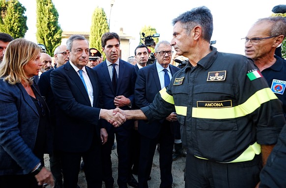 epa10188734 A handout photo made available by the Chigi Palace Press Office shows Italian Prime Minister Mario Draghi (L) visiting people in the Marche region where an overnight thunderstorm caused fl ...
