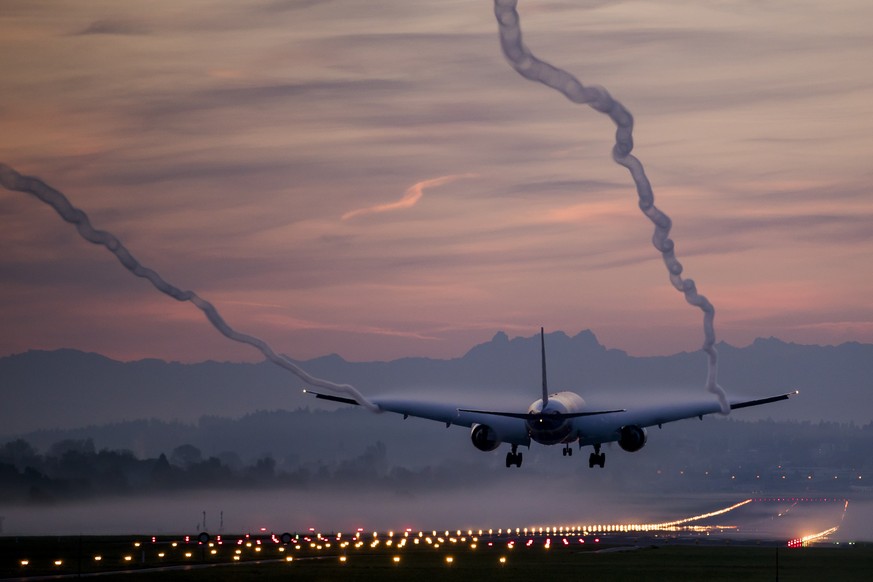 A Boeing 777-300 from Swiss International Airlines lands on a foggy morning at Zurich Airport, on Friday, October 13, 2017, in Zurich, Switzerland. The high humidity renders the air vortex visible. (K ...