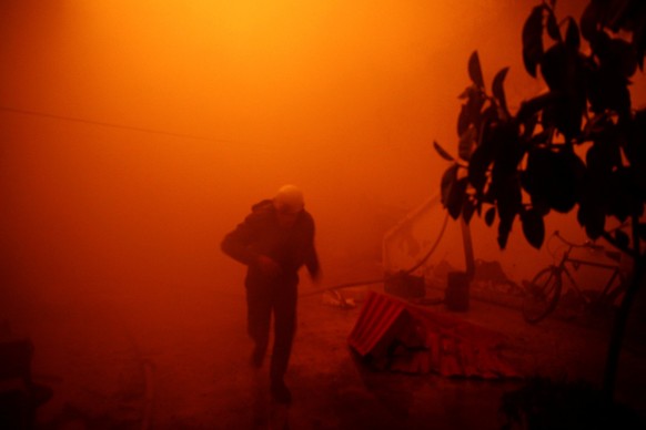 FILE PHOTO - A civil defence member runs at a site hit by an airstrike in the rebel held besieged Douma neighbourhood of Damascus, Syria November 23, 2016. REUTERS/Bassam Khabieh/File Photo REUTERS PI ...